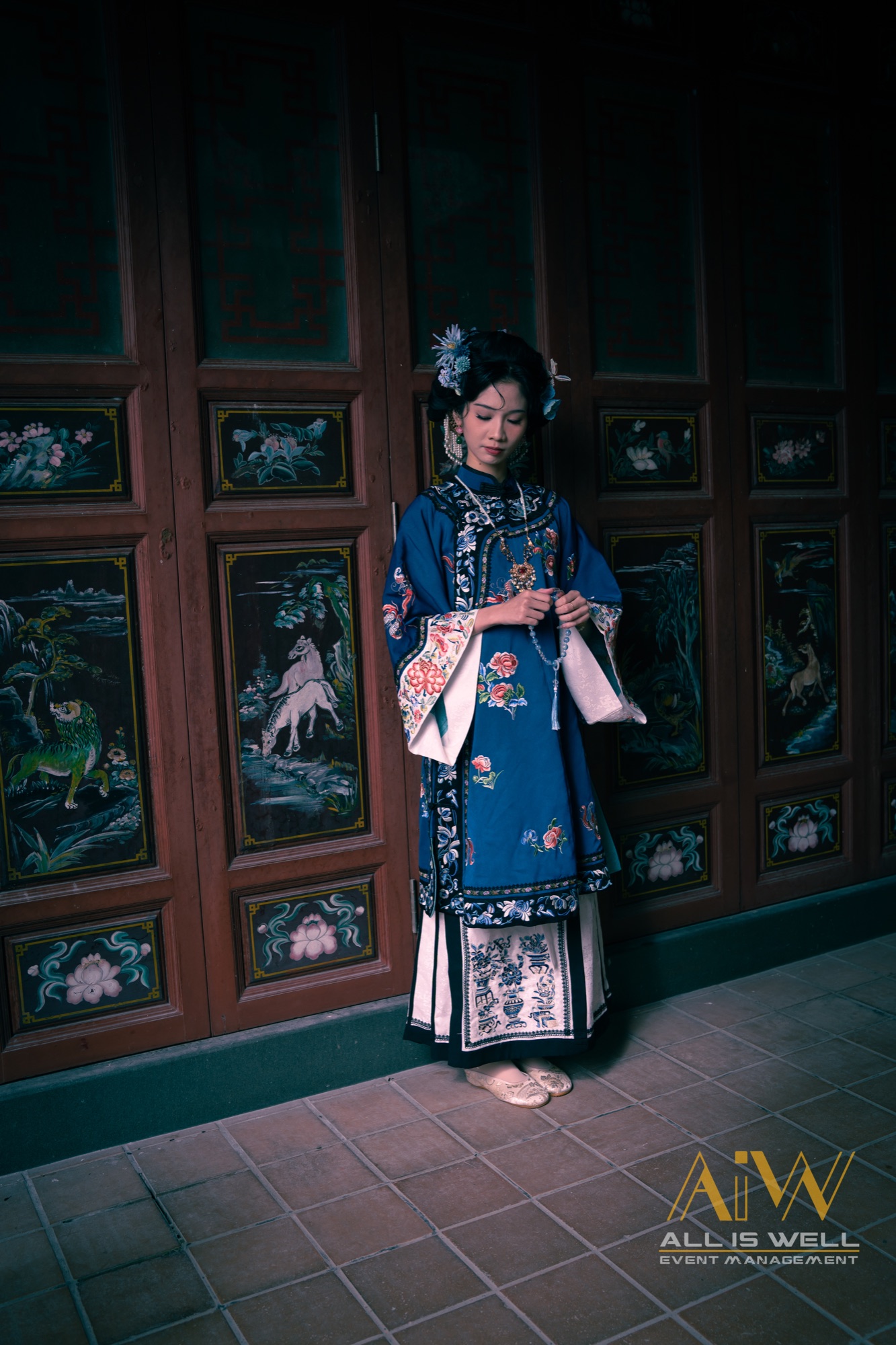 Portrait in blue traditional robe before painted temple panels