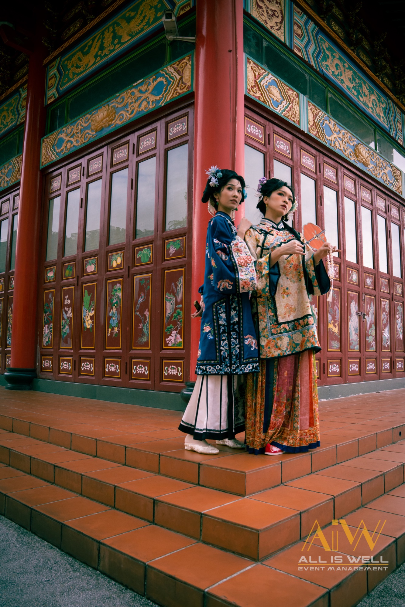 Two women in traditional dress at an ornate temple