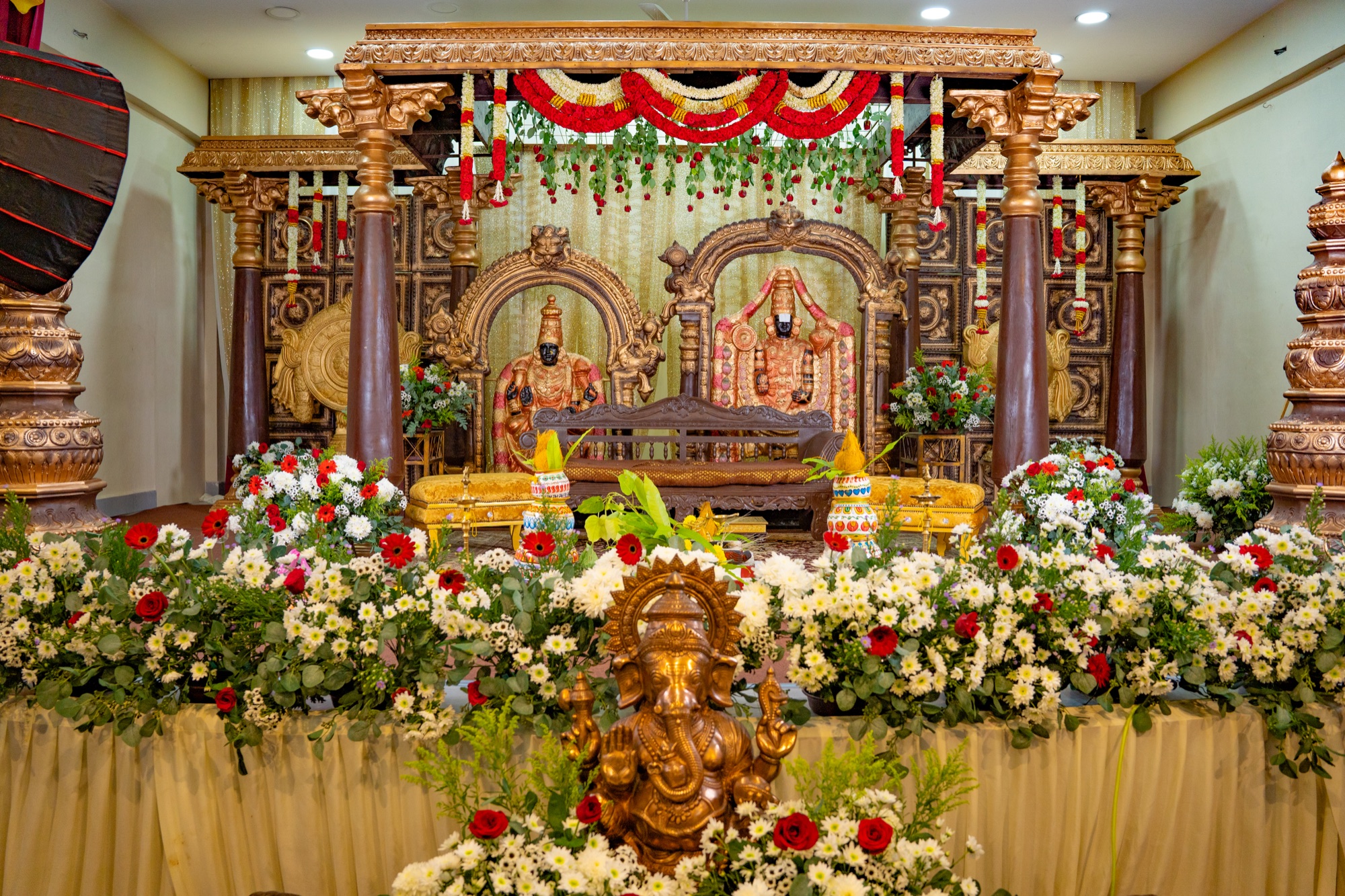 Elaborately decorated event stage with floral offerings