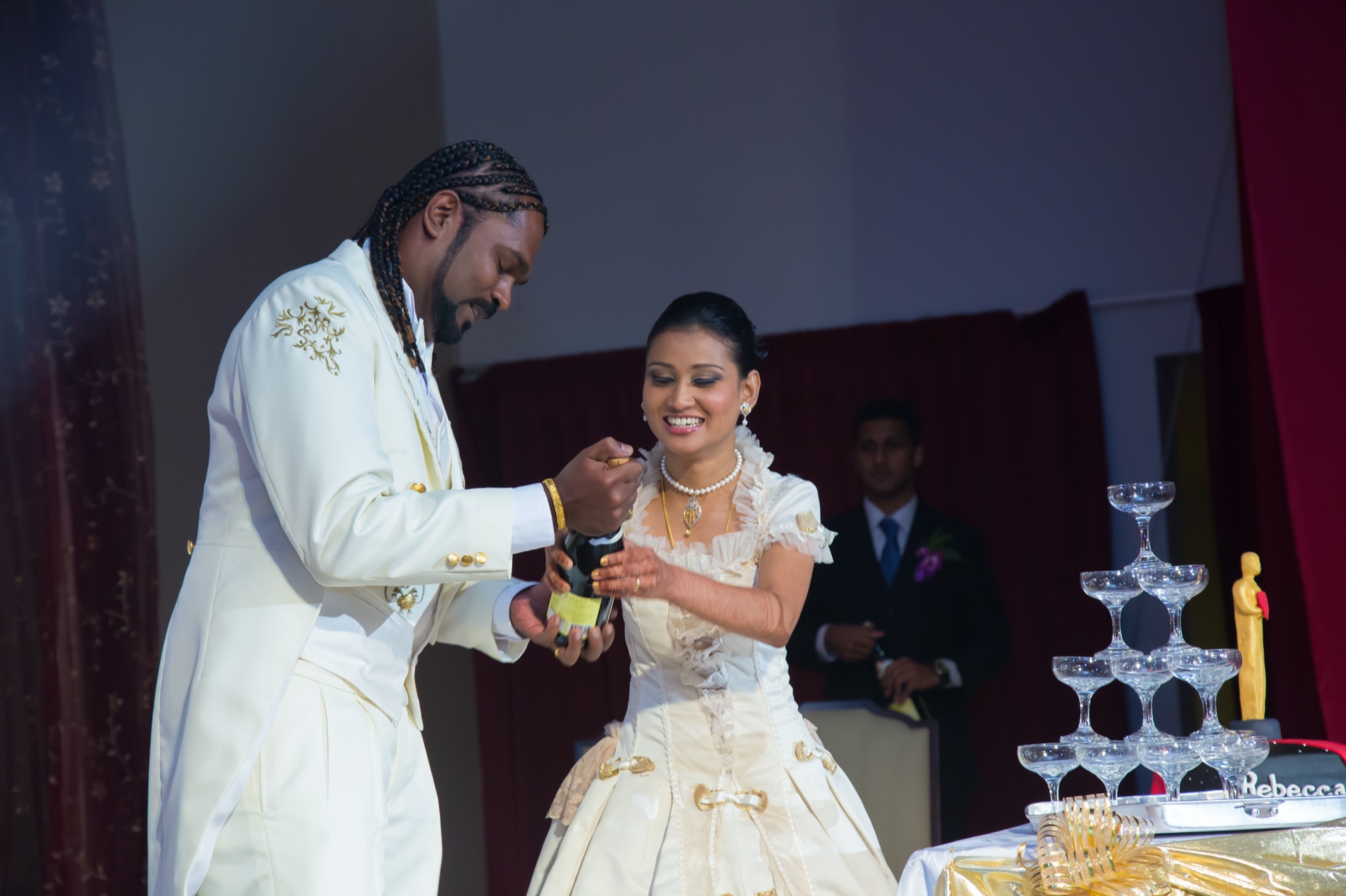 Newlyweds sharing a laugh while opening champagne