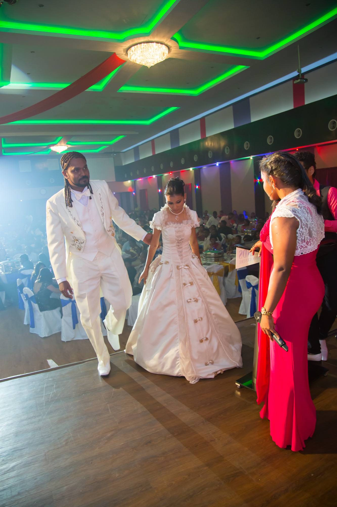 Grand entrance of bride and groom under coloured lights